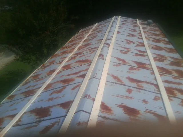 Rusted metal roof panels with new wood purlins before replacement — Storm Damage Roof Repair in Mooreville by Roofing Brothers