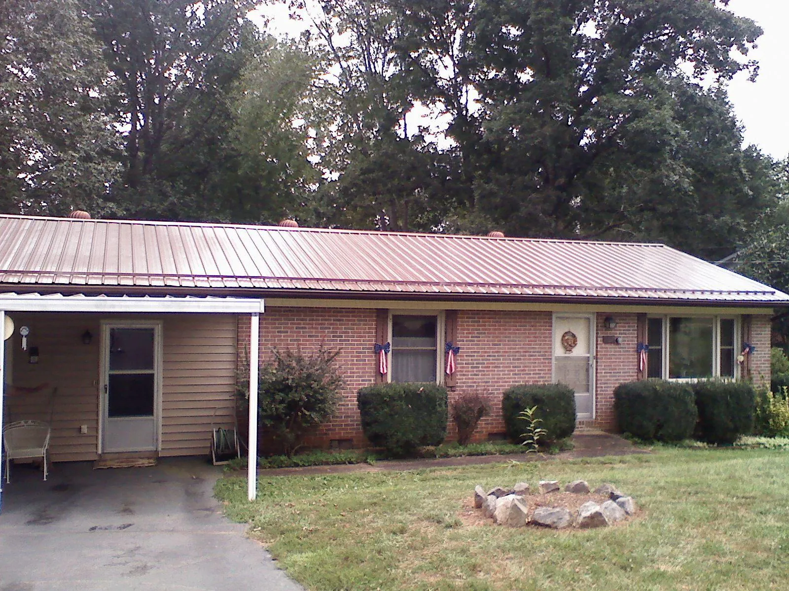 Bronze metal roof and carport on a brick ranch home — Roof Repair work by our crew in Mooreville