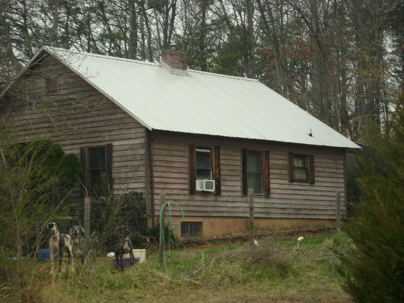 White metal roof on an old wood sided farmhouse, from a Metal Roof Installation job in Mooreville